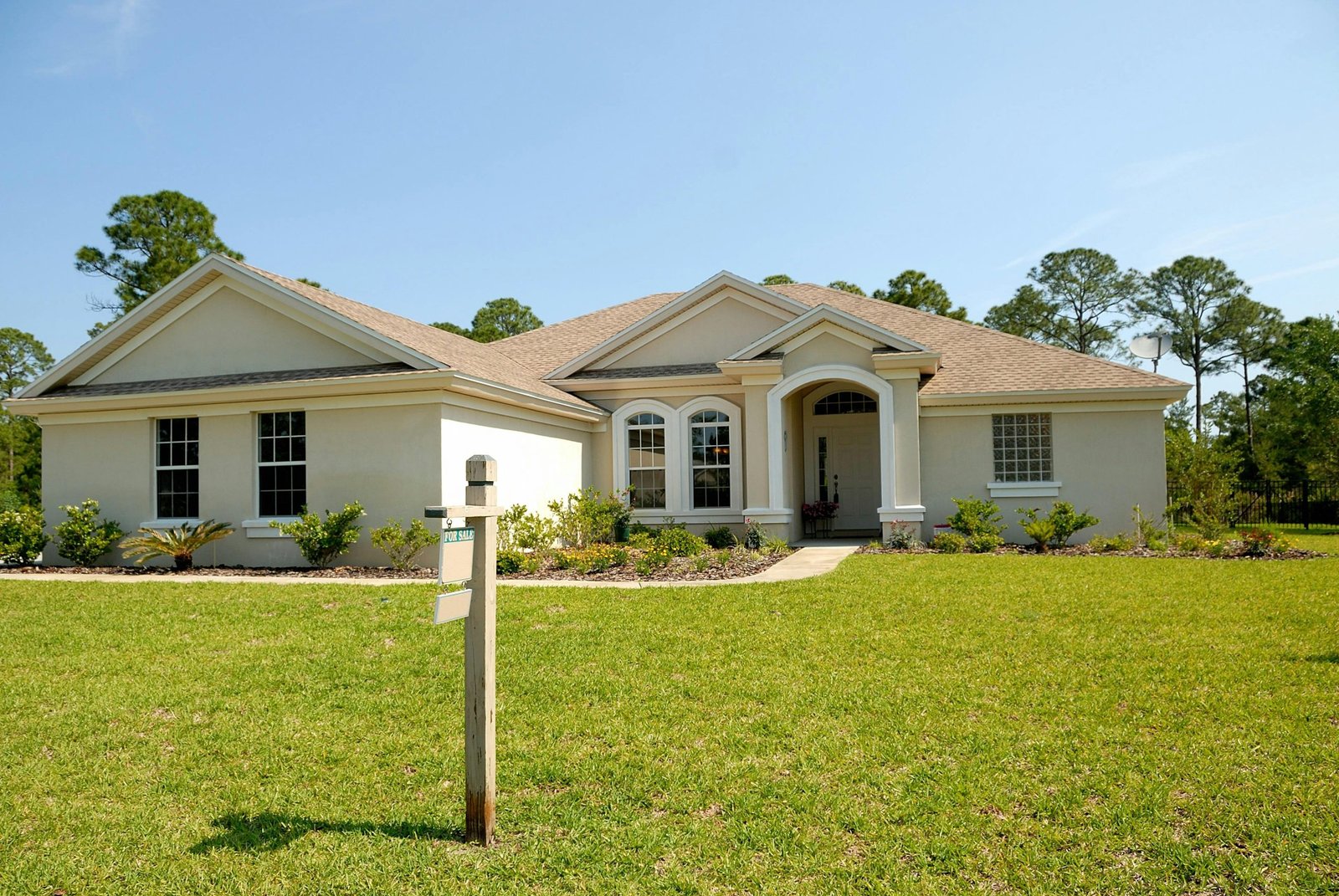 Home for sale with a for sale sign on the lawn